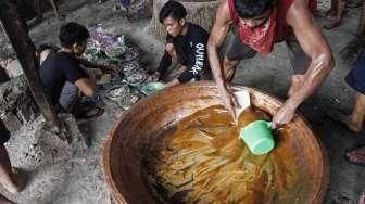 Pekerja memasak adonan dodol di rumah industri olahan dodol Betawi di kawasan Pasar Minggu, Jakarta, Kamis (23/6).[Suara.com/Kurniawan Mas'ud]