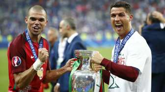 Dua bintang Portugal pepe dan Cristiano Ronaldo memegang trofi Euro setelah memenangi final melawan Prancis. Reuters/Michael Dalder Livepic