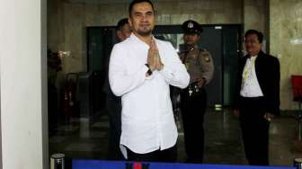 Artis Saipul Jamil melempar senyuman saat turun dari mobil tahanan  untuk diperiksa penyidik KPK, Jakarta, Selasa (19/7). [Suara.com/Oke Atmaja]