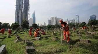 Pekerja Sudin Pertamanan dan Pemakaman Jakarta membuat lubang biopori di TPU Karet Bivak, Tanah Abang, Jakarta Pusat, Jumat (22/7). [Suara.com/Oke Atmaja]