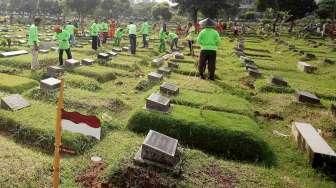 Pekerja Sudin Pertamanan dan Pemakaman Jakarta membuat lubang biopori di TPU Karet Bivak, Tanah Abang, Jakarta Pusat, Jumat (22/7). [Suara.com/Oke Atmaja]