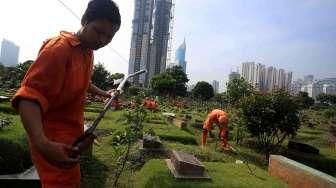 Pekerja Sudin Pertamanan dan Pemakaman Jakarta membuat lubang biopori di TPU Karet Bivak, Tanah Abang, Jakarta Pusat, Jumat (22/7). [Suara.com/Oke Atmaja]