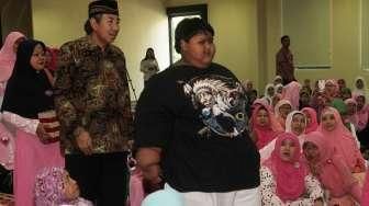 Arya Permana (10), bocah obesitas asal Karawang, turut hadir di peringatan Hari Anak Nasional di Pusdiklat Kemensos, Jakarta, Sabtu (23/7/2016), bersama Mensos Khofifah serta Sinta Nuriyah Wahid. [Suara.com/Oke Atmaja]