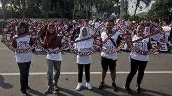 Relawan yang tergabung dalam Lentera Anak Indonesia menggelar aksi simpatik di Bundaran HI, Jakarta, Minggu (24/7/2016). [Suara.com/Kurniawan Mas'ud]