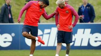 Pemain Barcelona Lionel Messi sedang berbicara dengan Luis Suarez saat latihan. Reuters / Darren Staples Livepic