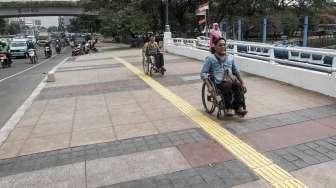 Sejumlah penyandang disabilitas dari Gerakan Aksesbilitas Umum Nasional (GAUN) DKI melakukan uji coba penggunaan trotoar ramah disabilitas di kawasan Jati Baru, Jakarta, Jumat (5/8).[Suara.com/Kurniawan Mas'ud]