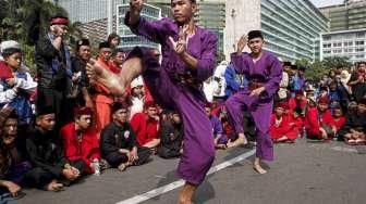 Sejumlah anak dan orang dewasa memperagakan atraksi silat dalam acara Lebaran Pendekar Betawi di Bundaran Hotel Indonesia (HI), Jakarta, Minggu (7/8/2016). [Suara.com/Kurniawan Mas'ud]