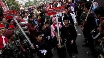Sejumlah anak dan orang dewasa memperagakan atraksi silat dalam acara Lebaran Pendekar Betawi di Bundaran Hotel Indonesia (HI), Jakarta, Minggu (7/8/2016). [Suara.com/Kurniawan Mas'ud]