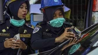 Petugas Dishub DKI Jakarta melakukan pemeriksaan uji KIR khusus kendaraan sewa berbasis transportasi online di kawasan Monas, Jakarta, Senin (15/8/2016). [Suara.com/Kurniawan Mas'ud]