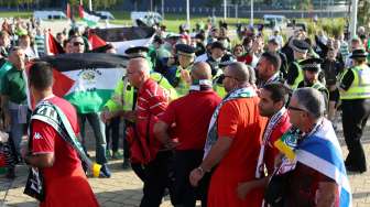 Petugas keamanan memisahkan fans Celtic FC dengan pendukung Hapoel Be'er Sheva (Israel), jelang laga play-off Liga Champions, Rabu (17/8/2016), di Glasgow, Skotlandia. [Reuters/Russell Cheyne]