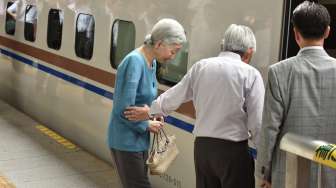 Kaisar Jepang, Akihito, bersama istrinya Michiko, Sabtu (20/8/2016), memasuki gerbong kereta cepat di Stasiun Tokyo, saat hendak berangkat menjalani kunjungan ke Prefektur Nagano dan Gunma. [Kazuhiro Nogi/AFP]