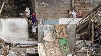 Sejumlah warga tampak membongkar sendiri bangunan rumahnya sebelum eksekusi pemukiman di bantaran Sungai Ciliwung, kawasan Bukit Duri, Jakarta, Selasa (23/8/2016). [Suara.com/Kurniawan Mas'ud]