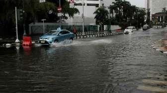 Beberapa kendaraan tampak melintasi jalanan yang tergenang air di Jalan Agus Salim, kawasan Menteng, Jakarta Pusat, Selasa (30/8/2016). [Suara.com/Oke Atmaja]