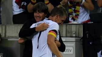 Pelatih Jerman Joachim Loew memeluk Bastian Schweinsteiger usai laga terakhirnya bersama Jerman [Reuters]