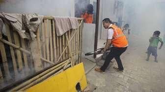 Petugas melakukan pengasapan (fogging) untuk memutus mata rantai berkembangnya nyamuk, di perumahan padat penduduk di kawasan Pademangan, Jakarta, Sabtu (10/9/2016). [Suara.com/Kurniawan Mas'ud]