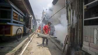 Petugas melakukan pengasapan (fogging) untuk memutus mata rantai berkembangnya nyamuk, di perumahan padat penduduk di kawasan Pademangan, Jakarta, Sabtu (10/9/2016). [Suara.com/Kurniawan Mas'ud]