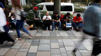 Sejumlah orang tampak mengisi antrean calon pembeli iPhone 7 yang bakal segera dirilis, di depan Apple Store di kawasan perbelanjaan Omotesando, Tokyo, Kamis (15/9/2016). [Reuters/Toru Hanai]