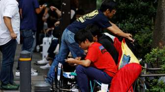 Sejumlah orang tampak mengisi antrean calon pembeli iPhone 7 yang bakal segera dirilis, di depan Apple Store di kawasan perbelanjaan Omotesando, Tokyo, Kamis (15/9/2016). [Reuters/Toru Hanai]