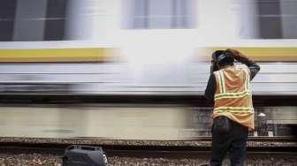 Sejumlah pekerja melakukan perawatan rel kereta api yang menghubungkan Jakarta-Bekasi di jalur Cipinang, Jakarta, Minggu (9/10/2016). [Suara.com/Kurniawan Mas'ud]