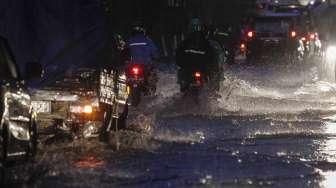 Sejumlah kendaraan tampak melintas di antara genangan banjir di kawasan Kalimalang, Jakarta, Minggu (9/10/2016). [Suara.com/Kurniawan Mas'ud]