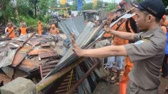 Petugas melakukan pembongkaran bangunan semipermanen di bantaran Kali Krukut, Jakarta Selatan, Kamis (13/10/2016). [Suara.com/Oke Atmaja]