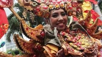 Sejumlah perempuan mengenakan busana penari topeng dalam acara Hajatan Bank DKI saat Car Free Day (CFD) di kawasan Bundaran HI, Jakarta, Minggu (16/10/2016). [Suara.com/Oke Atmaja]