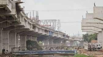 Sejumlah pekerja tampak menyelesaikan pembangunan proyek jalan tol Bekasi-Cawang-Kampung Melayu (Becakayu), di kawasan Jakarta, Minggu (30/10/2016). [Suara.com/Kurniawan Mas'ud]