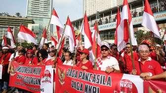 Peserta membentangkan bendera Merah Putih raksasa saat mengikuti Karnaval Cinta Budaya NKRI di kawasan Bunderan HI, Jakarta, Minggu (20/11/2016). [Suara.com/Oke Atmaja]