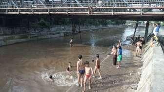 Sejumlah anak tampak asyik bermain air di kawasan Sungai Kenari, Jakarta, Minggu (20/11/2016). [Suara.com/Oke Atmaja]