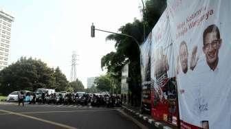 Pengguna jalan melintasi baliho bergambar tiga pasang calon Gubernur dan Wakil Gubernur DKI Jakarta di kawasan Tugu Tani, Jakarta, Selasa (22/11). [Suara.com/Oke Atmaja]