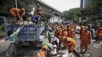 Petugas Dinas Kebersihan bersama Petugas Dinas Tata Air DKI Jakarta membersihkan lumpur yang mengendap di saluran air di Jakarta, Minggu (27/11/2016). [Suara.com/Kurniawan Mas'ud]