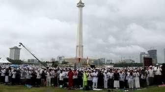 Massa Aksi Damai 2 Desember melakukan salat Jumat berjamaah di bawah guyuran hujan di kawasan Monumen Nasional (Monas), Jakarta, Jumat (12/2/2016). [Suara.com/Oke Atmaja]