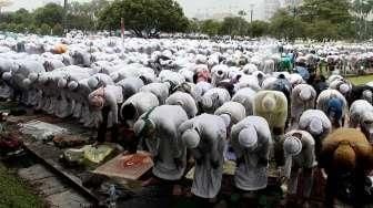 Massa Aksi Damai 2 Desember melakukan salat Jumat berjamaah di bawah guyuran hujan di kawasan Monumen Nasional (Monas), Jakarta, Jumat (12/2/2016). [Suara.com/Oke Atmaja]