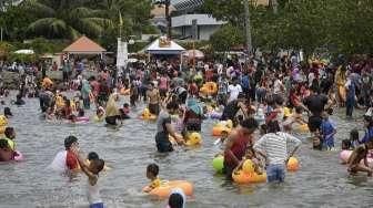 Pengunjung dari berbagai daerah memadati Pantai Festival di kawasan wisata Taman Impian Jaya Ancol, Jakarta, Minggu (25/12/2016). [Suara.com/Kurniawan Mas'ud]