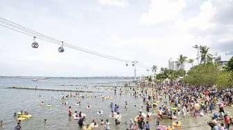 Pengunjung dari berbagai daerah memadati Pantai Festival di kawasan wisata Taman Impian Jaya Ancol, Jakarta, Minggu (25/12/2016). [Suara.com/Kurniawan Mas'ud]