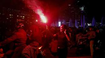 Warga Jakarta menyalakan kembang api menyambut tahun baru 2017 di kawasan Bundaran HI, Jakarta, Minggu (1/1/2017).[suara.com/Kurniawan Mas'ud]