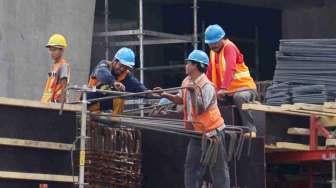 Pekerja melakukan aktivitas di atas gedung bertingkat di kawasan Jalan Jenderal Sudirman, Jakarta, Rabu (25/1).