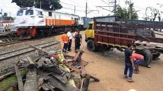 Petugas mengevakuasi sebuah truk bak terbuka yang tertabrak kereta api Cirebon Express di perlintasan depan LP Cipinang, Jakarta, Rabu (25/1).