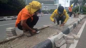 Sejumlah pekerja Suku Dinas Jakarta Pusat melakukan perbaikan separator (pembatas jalur) di Jalan M.H. Thamrin, kawasan Bundaran Hotel Indonesia, Jakarta, Jumat (27/1).