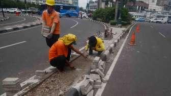 Sejumlah pekerja Suku Dinas Jakarta Pusat melakukan perbaikan separator (pembatas jalur) di Jalan M.H. Thamrin, kawasan Bundaran Hotel Indonesia, Jakarta, Jumat (27/1).