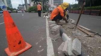 Sejumlah pekerja Suku Dinas Jakarta Pusat melakukan perbaikan separator (pembatas jalur) di Jalan M.H. Thamrin, kawasan Bundaran Hotel Indonesia, Jakarta, Jumat (27/1).