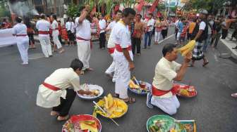 Sejumlah umat menggelar ritual tolak bala Imlek 2568 di Jalan Raya Kawasan Kuta, Bali, Jumat (27/1).