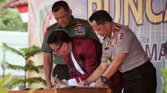 Ketua Dewan Pers Yoseph Adhi Prasetyo (kiri) menandatangani nota kesepahaman atau memorandum of understanding (MOU) dengan Panglima TNI Jenderal Gatot Nurmantyo (belakang) dan Kapolri Jenderal Polisi Tito Karnavian (kanan), pada puncak acara Hari Pers Nasional di Ambon, Maluku, Kamis (9/2).