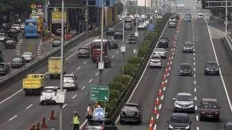 Sejumlah kendaraan roda empat melintas di ruas jalan Tol Dalam Kota ketika diberlakukan uji coba 