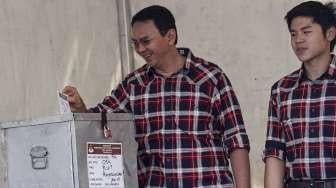 Calon Gubernur Petahana Basuki Tjahja Purnama (Ahok) beserta istrinya Veronica dan putra sulungnya Nicolas memberikan hak suara di TPS 54, Kompleks Pantai Indah Mutiara, Penjaringan, Jakarta, Rabu (15/2).