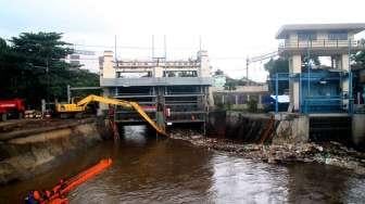 Petugas membersihkan sampah pada aliran Sungai Ciliwung yang menyumbat di Pintu Air Manggarai, Jakarta, Sabtu (18/2).