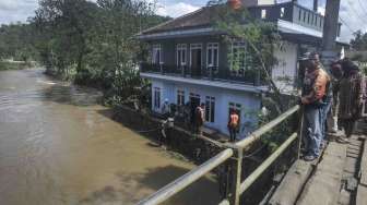 Warga membersihkan lumpur akibat banjir bandang Sungai Cidadap di Desa Sirnajaya, Gunung Halu, Kabupaten Bandung Barat (KBB), Jawa Barat, Jumat (24/2).