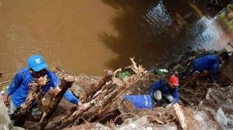 Pekerja Harian Lepas (PHL) Dinas Tata Air DKI Jakarta membetulkan turap air yang longsor di kawasan Matraman, Jakarta, Minggu (26/2/2017). [Suara.com/Oke Atmaja]