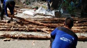 Pekerja Harian Lepas (PHL) Dinas Tata Air DKI Jakarta membetulkan turap air yang longsor di kawasan Matraman, Jakarta, Minggu (26/2/2017). [Suara.com/Oke Atmaja]