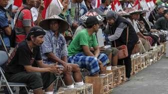 Puluhan petani dari kawasan Pegunungan Kendeng kembali melakukan aksi protes dengan mengecor kaki menggunakan semen di depan Istana Negara, Jakarta, Kamis (16/3/2017). [Suara.com/Kurniawan Mas'ud]